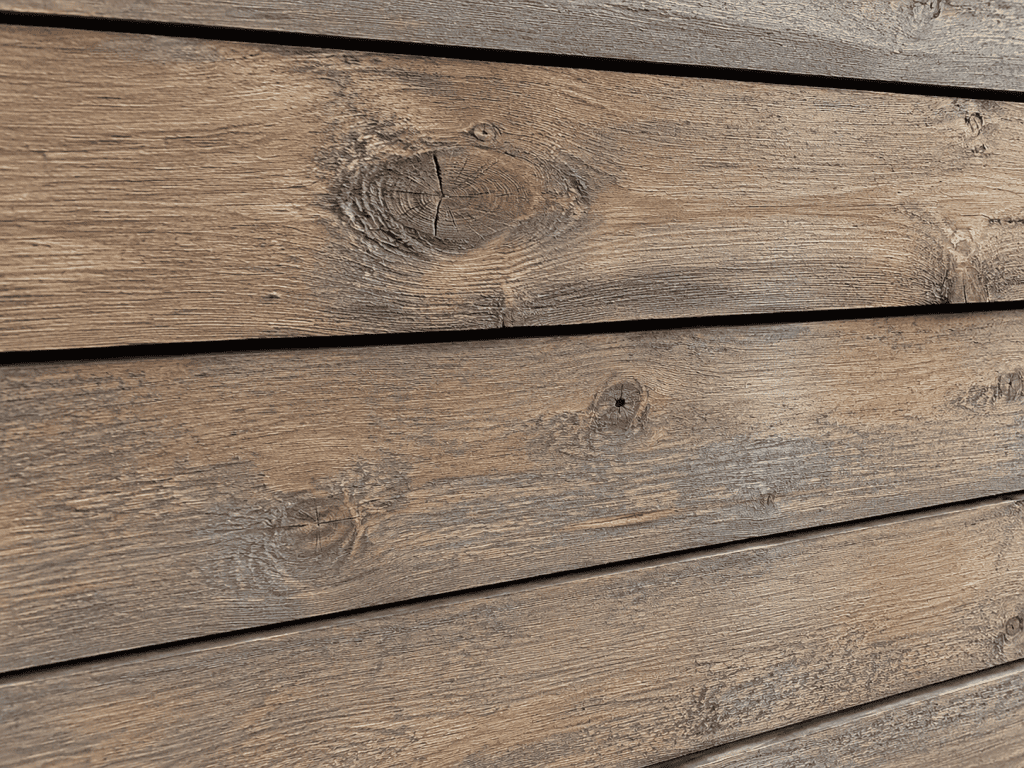 Woodtone RusticSeries lap siding in a weathered driftwood-brown woodgrain finish