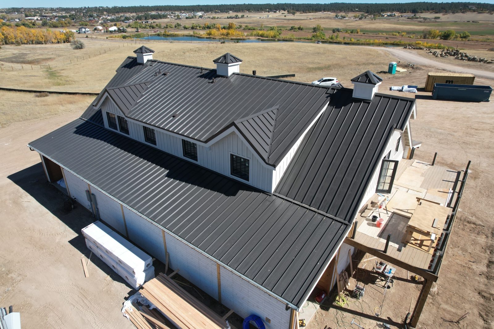 Custom dark bronze standing seam metal roof on a modern farmhouse in Franktown, Colorado